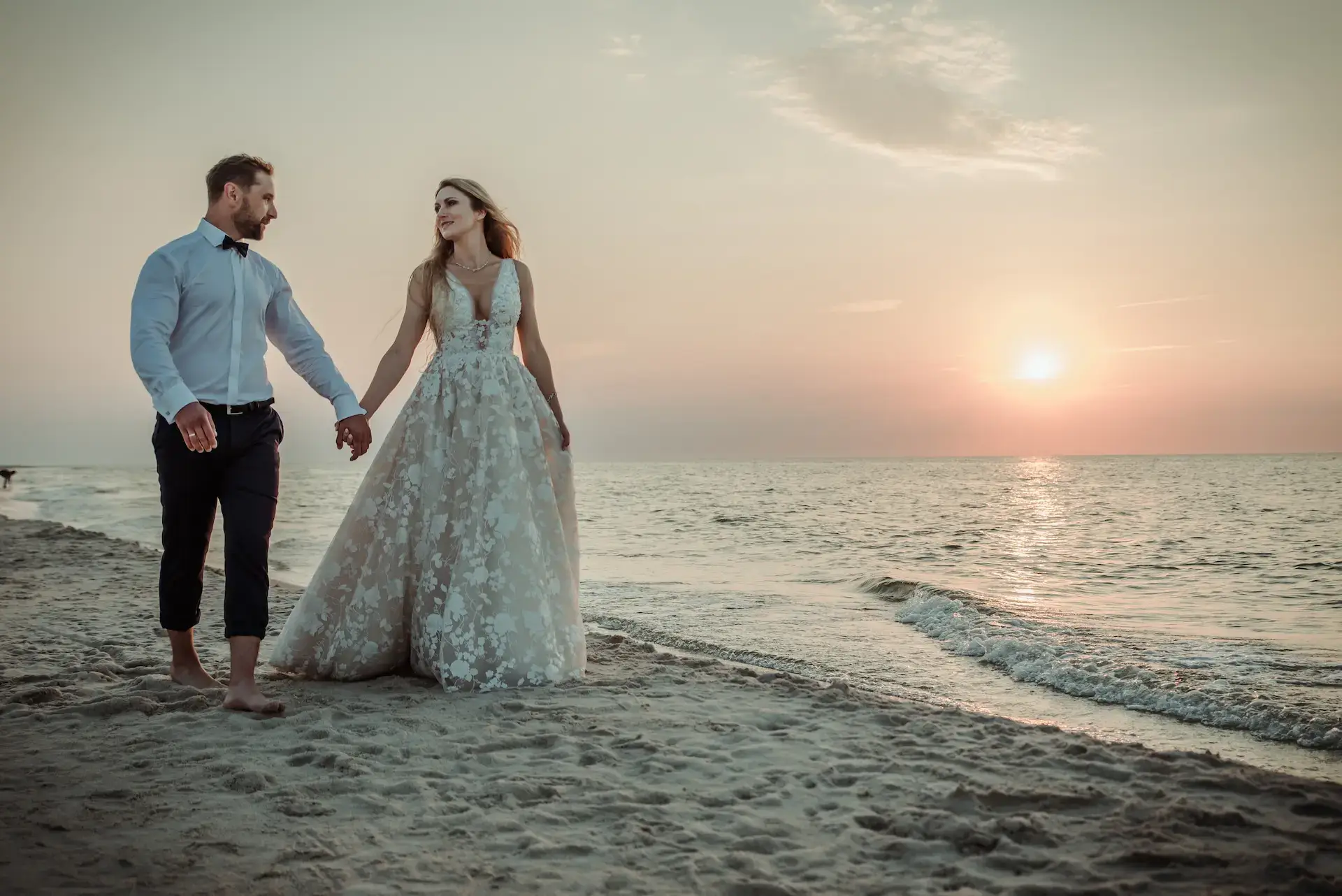 Naturalna fotografia ślubna - para młoda boso na piaszczystej plaży nad morzem o zachodzie słońca w Trójmieście