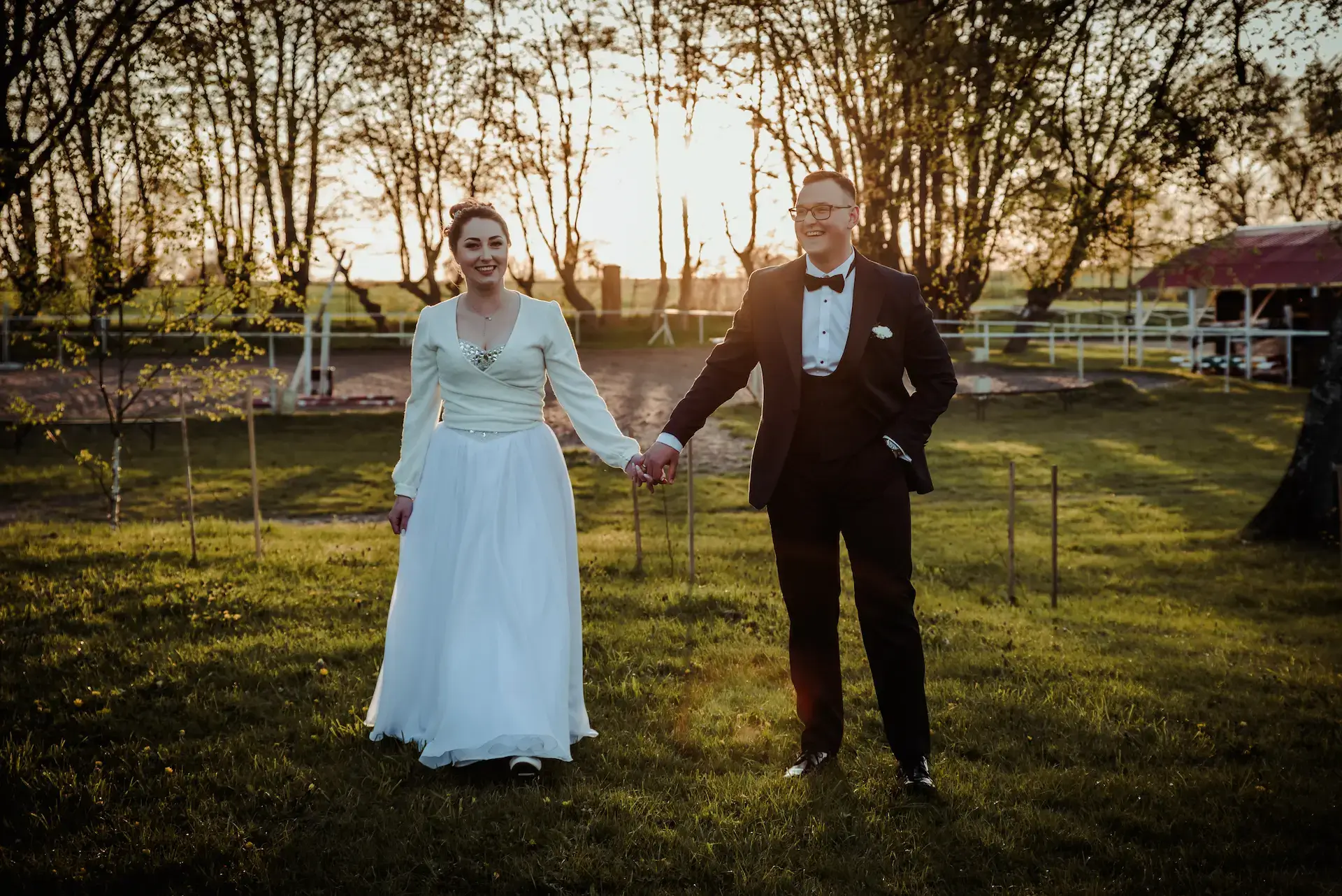 Reportaż ślubny Starogard Gdański - uśmiechnięta para młoda na łące o zachodzie słońca - fotograf i kamerzysta na wesele